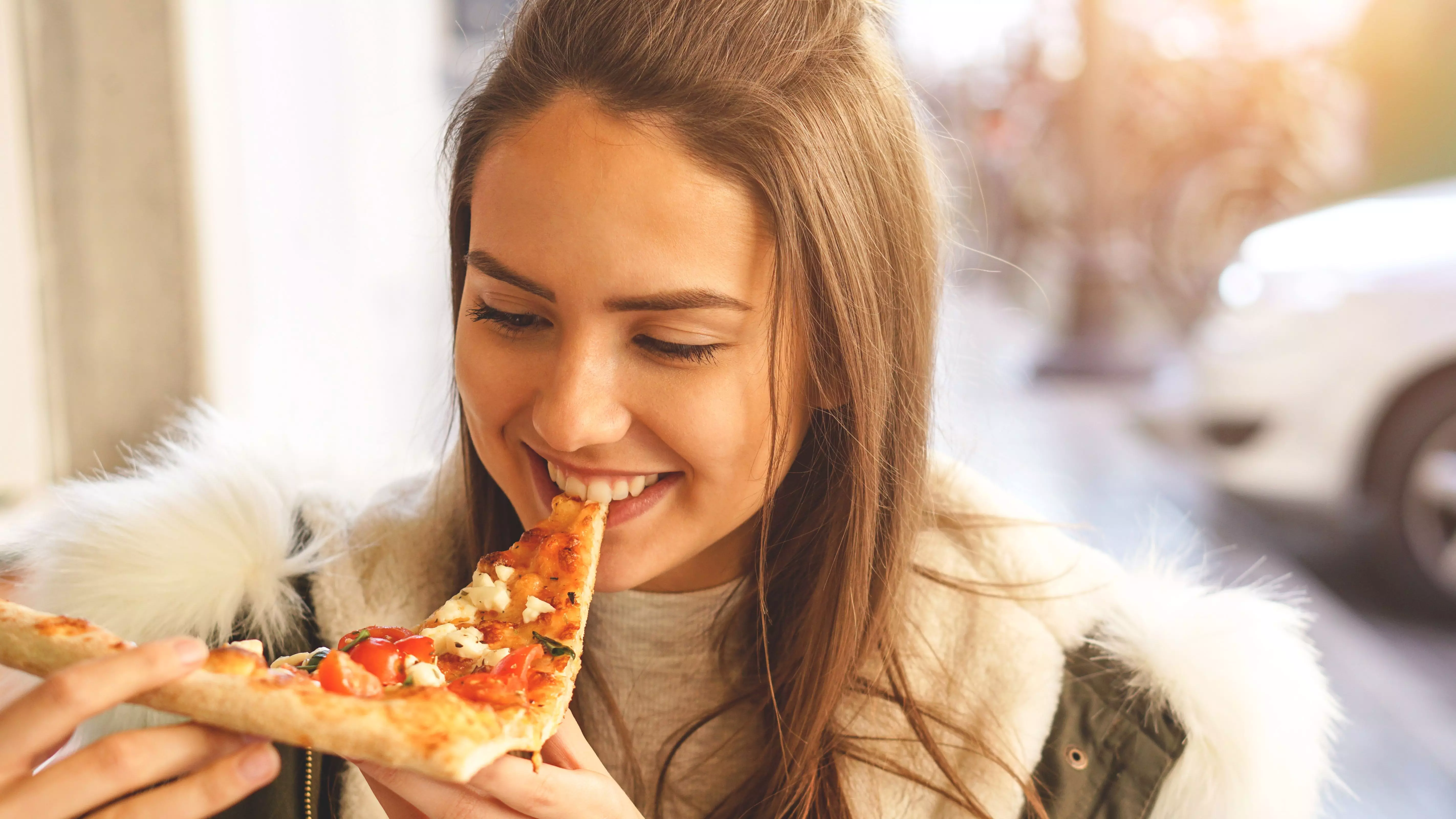 девушка ест пиццу с сыром