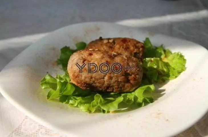 два говяжьих кеббе с начинкой в тарелке на салатных листах
