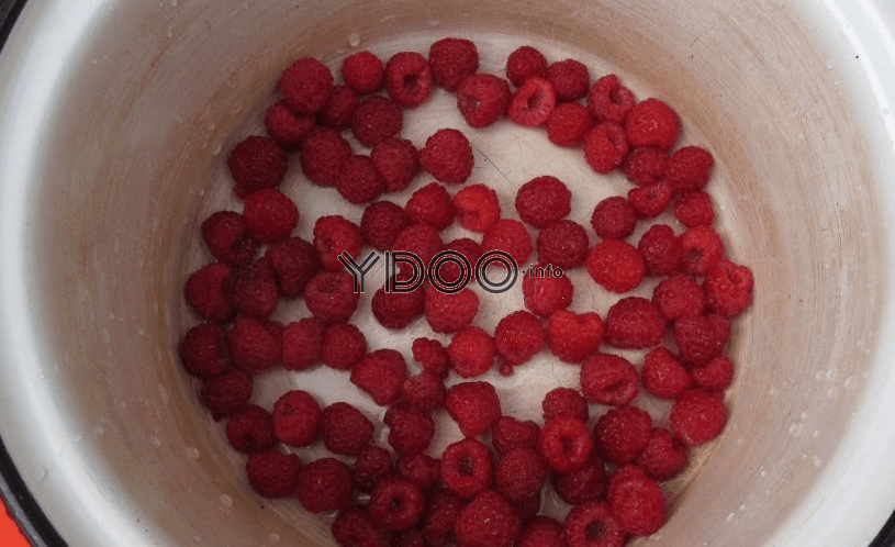 ягоды свежей малины на дне кастрюли