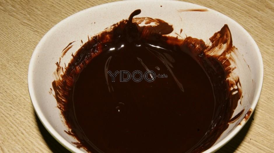 растопленный шоколад в глубокой белой мисочке на столе