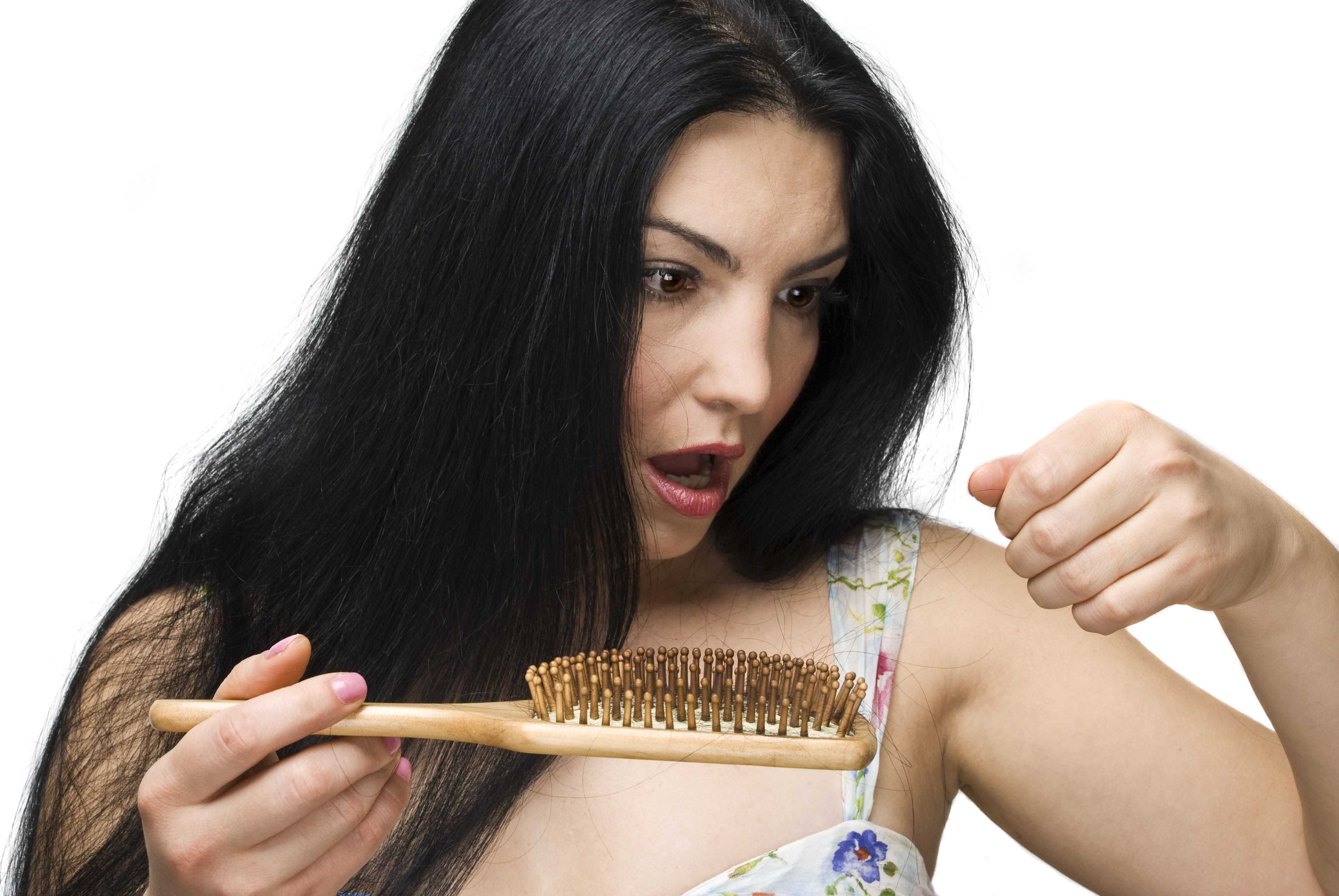 У женщины очень сильно выпадают волосы. Расческа для волос. Расчесывание волос. Девушка с расчёской выпадают волосы.