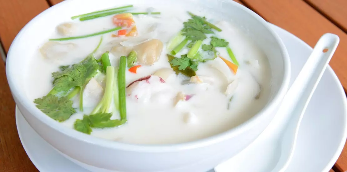 азиатский суп с кокосовым молоком в белой тарелке