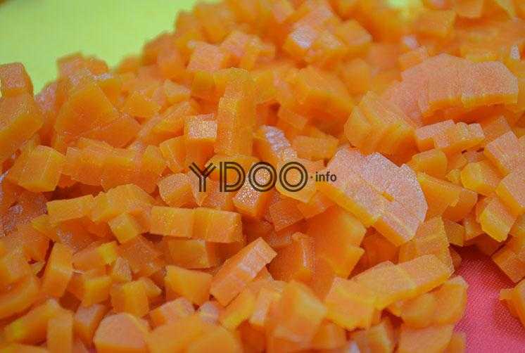 вареная морковь, нарезанная кубиками, лежит на доске