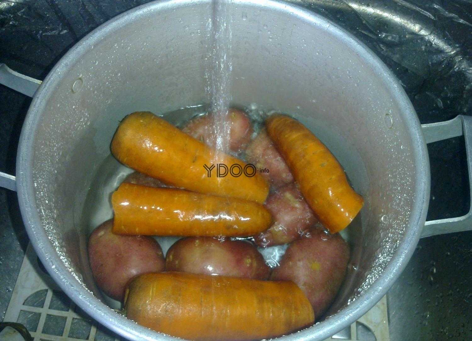 в кастрюлю набирают воду, внутри лежит четыре морковки и картофель