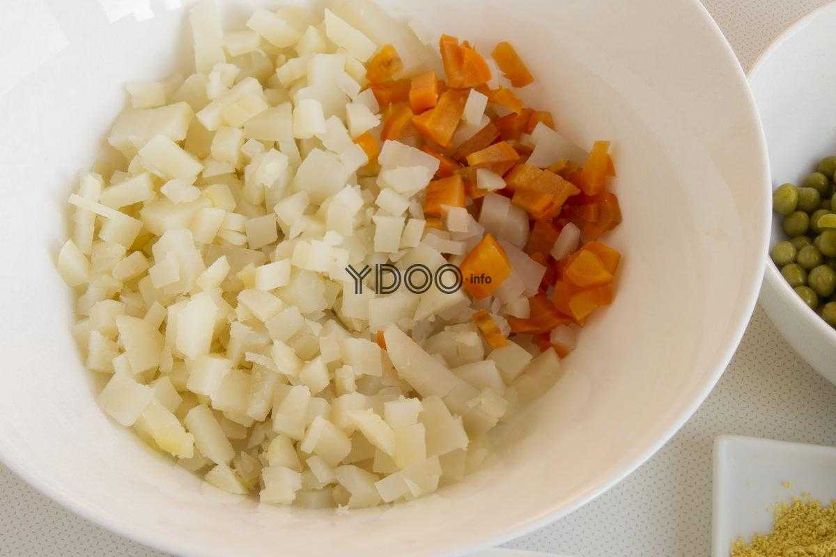 в белой тарелке лежат нарезанные кубиками картофель и морковь
