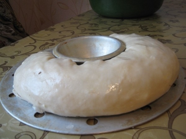 сырой рулет с начинкой внутри на чаше пароварки на столе, застеленном скатертью