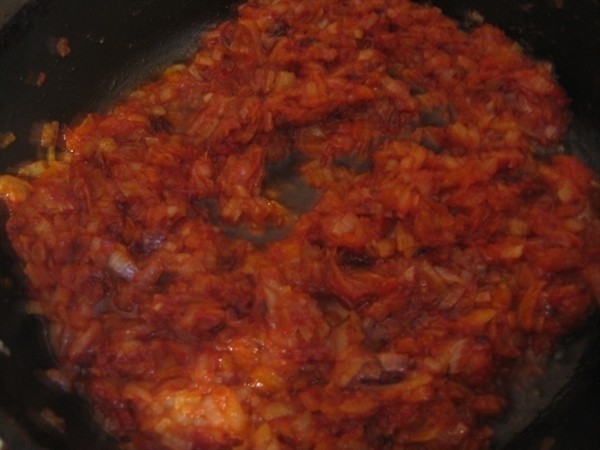 жареный репчатый лук, перемешанный с томатной пастой, в сковороде