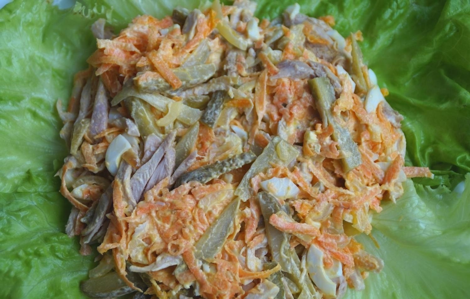 овощная зажарка, перемешанная с вареной курицей и солеными огурцами на листьях салата