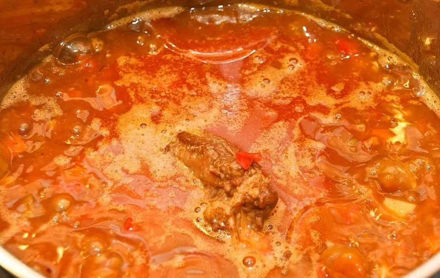 томатный суп с кусочками мяса и картофелем в сковороде