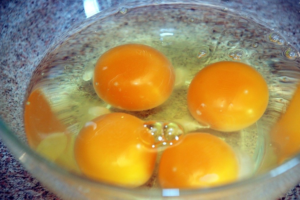 четыре куриных яйца в стеклянной миске
