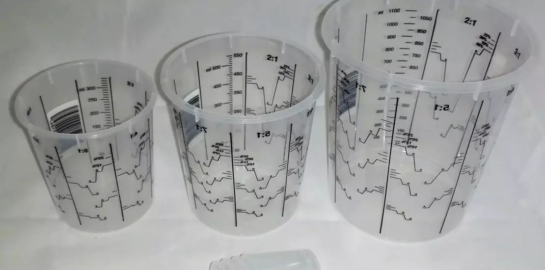 три разных мерных стакана на столе