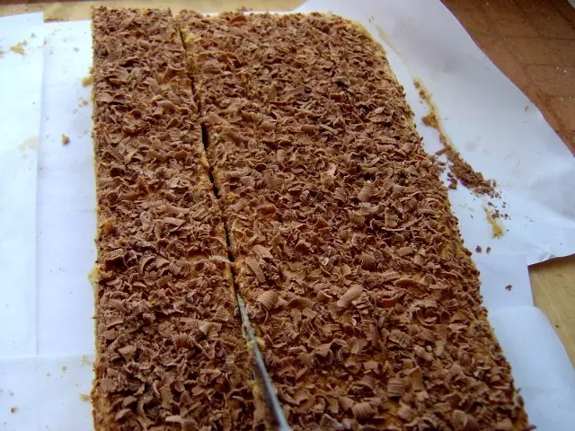 торт из коржей, крема и тертого шоколада, разрезанный на полоски